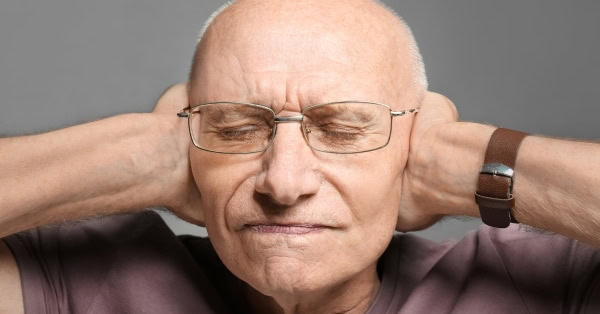 גבר מכסה אוזניים עם בעיית שמיעה